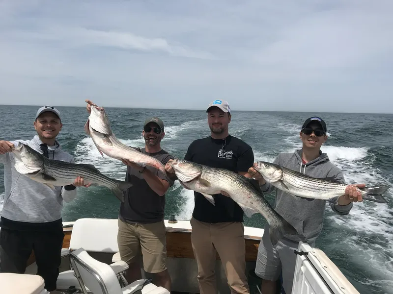 4 guys holding fish they caught