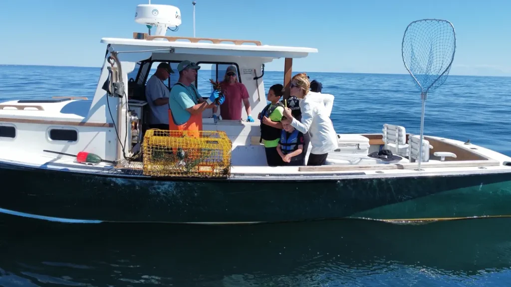 Captain Dave on the D-Tails, showing a lobster to guests