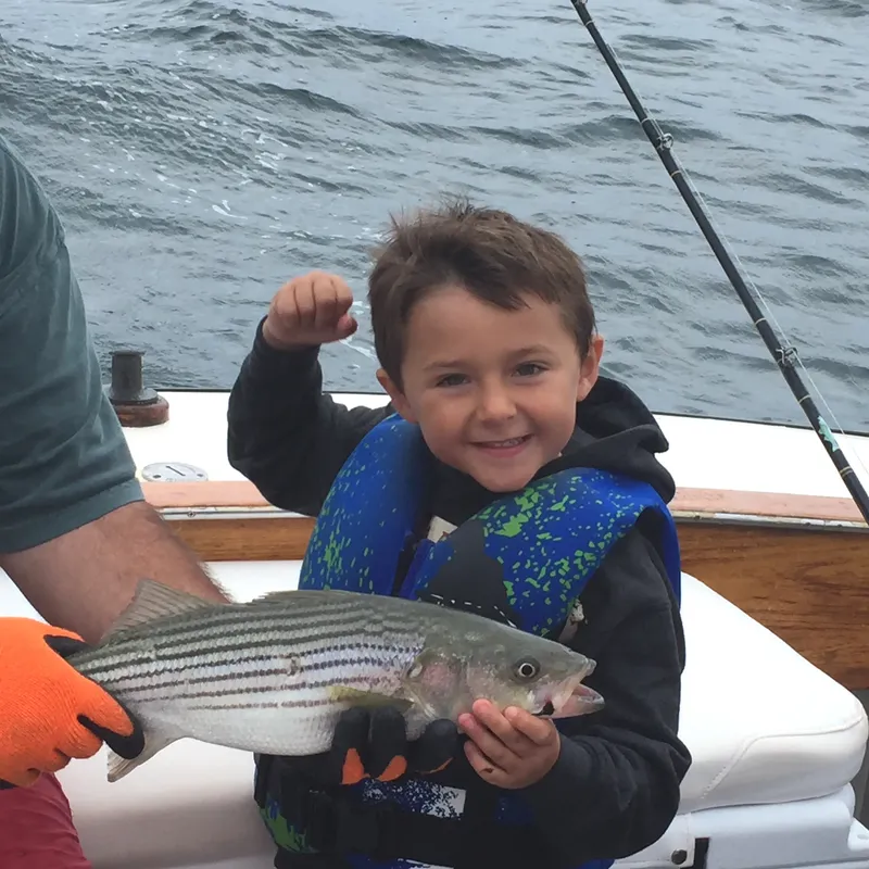 A smiling little boy holding his fish